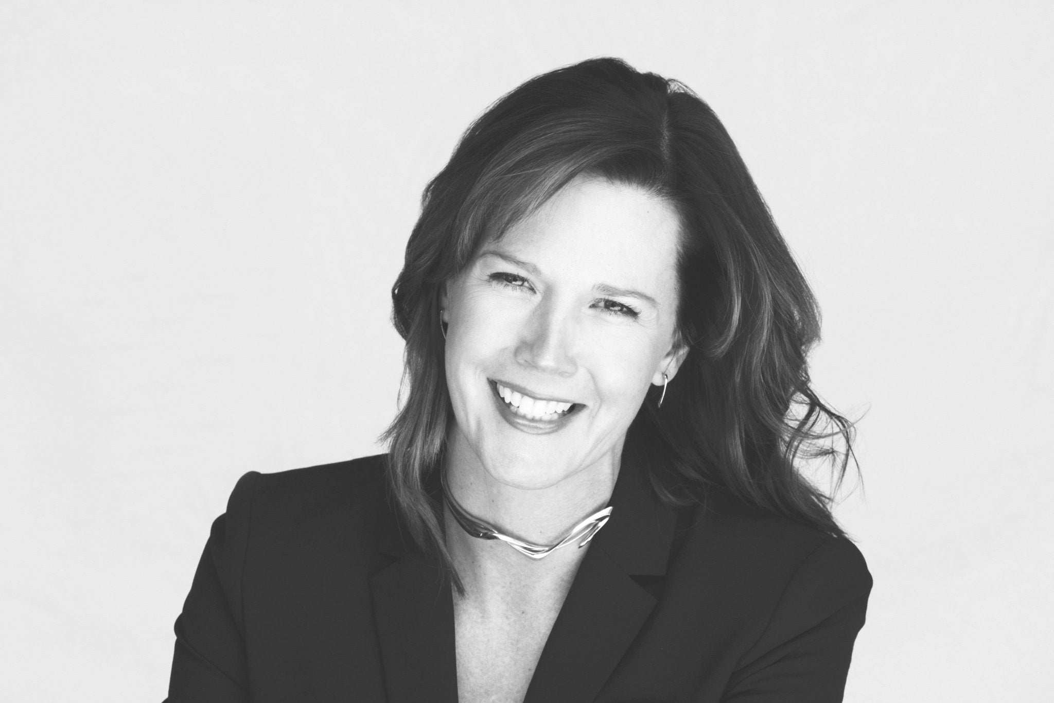 Black and white portrait of smiling woman wearing sterling silver choker and earrings from Celebration of Women series