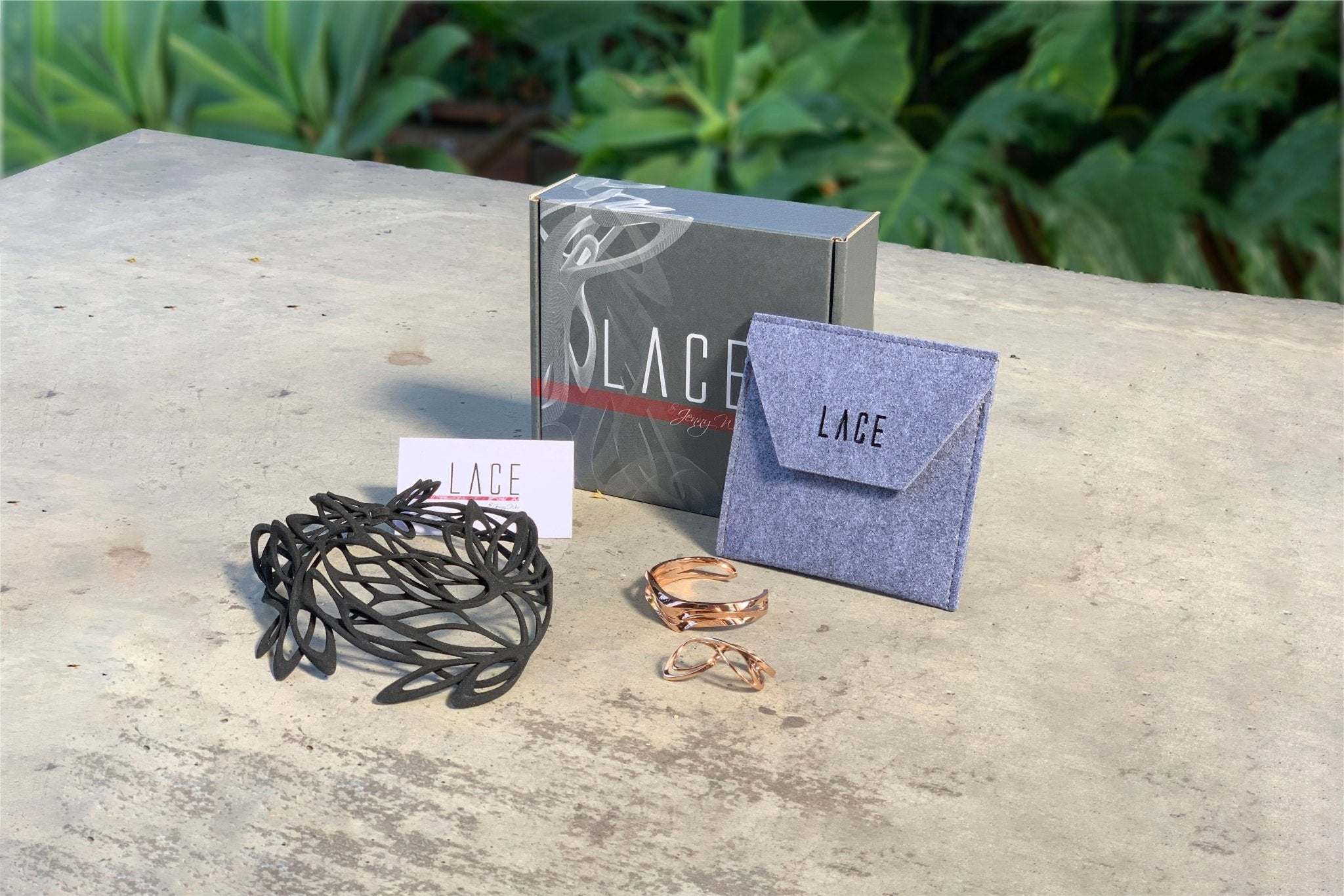 Mother’s Day gift set with black bracelet, rose gold rings, and LACE gift box on outdoor table