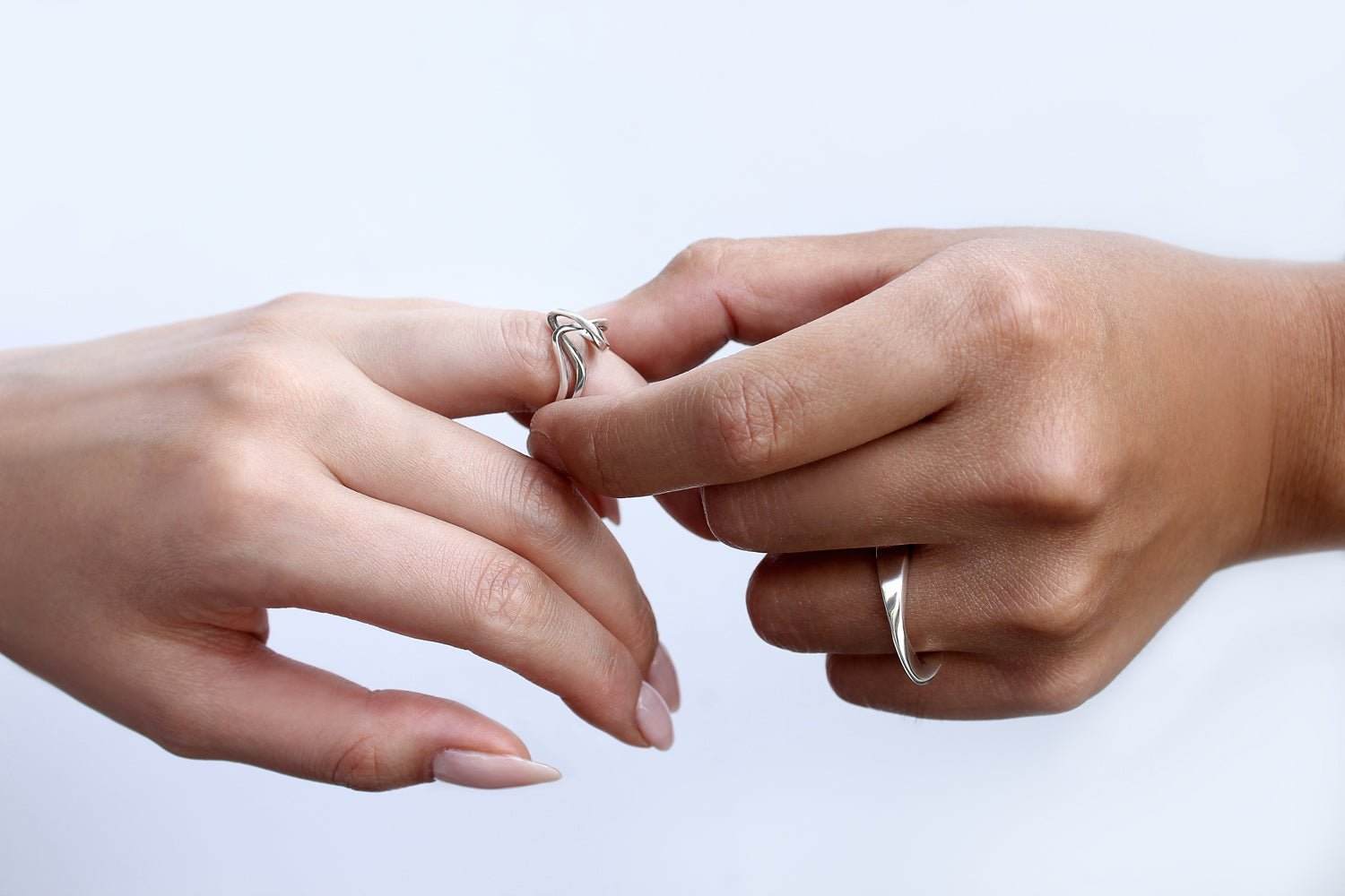 Two hands with silver rings gently touching fingers on a light blue background Our Response to COVID-19