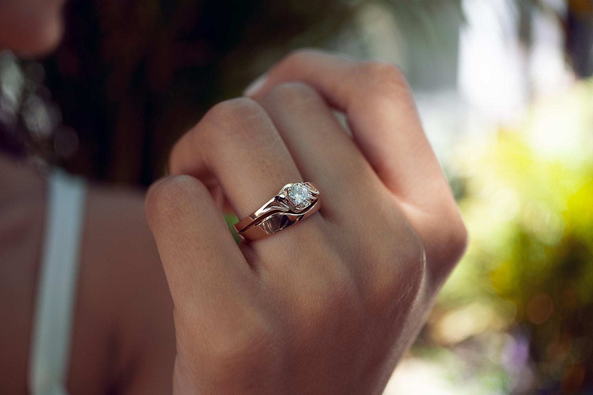 Close-up of a hand wearing the Iris Diamond Ring with a half carat diamond and minimalist design in natural light