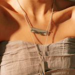 Adagio stainless steel pendant necklace with twisting and stacking curves worn on a woman