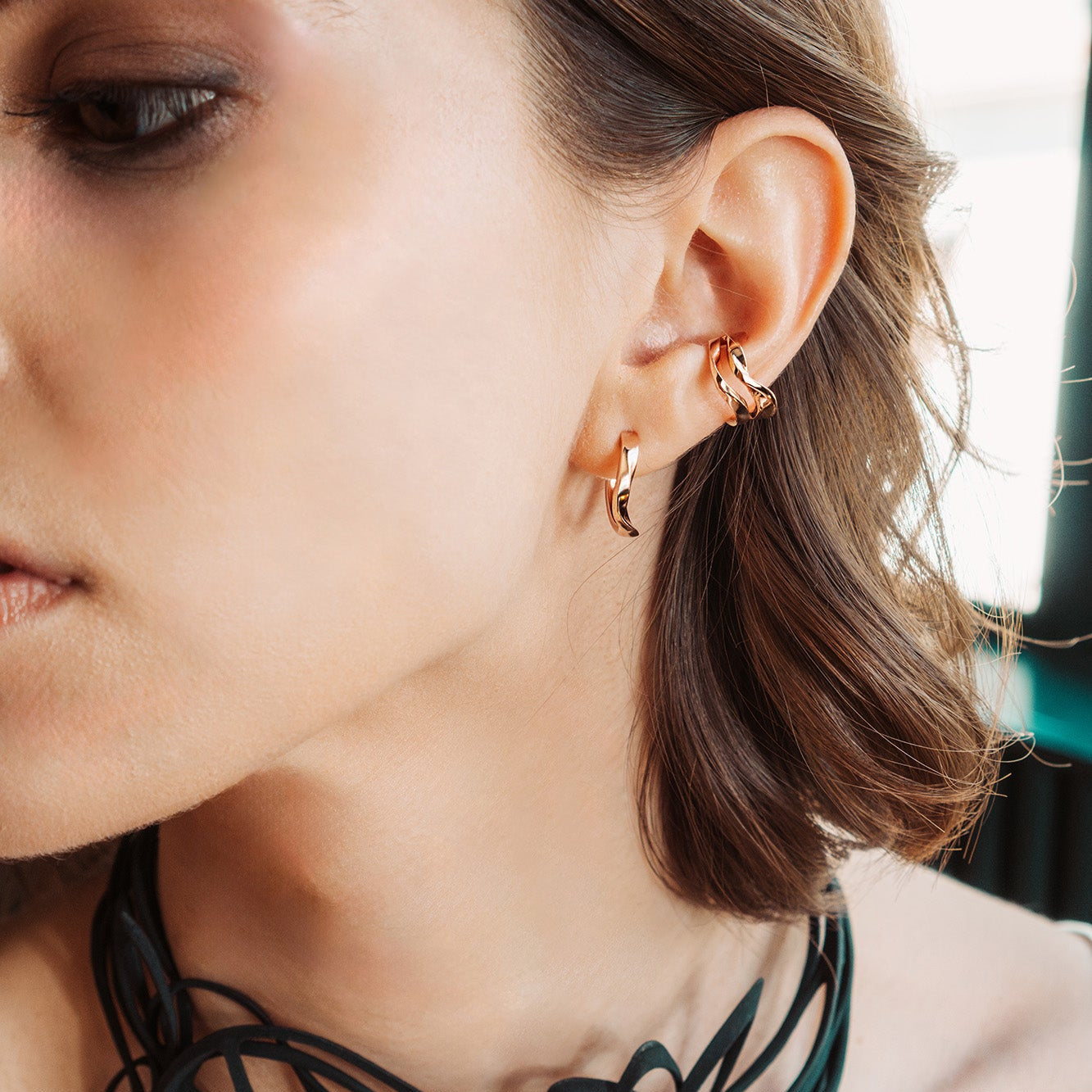 Close-up of a woman wearing rose gold Linea Earrings Set with ear cuff and mini hoops