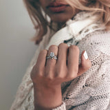 Engagement ring samples set with four nylon ring designs displayed on a woman's hand wearing a knitted sweater