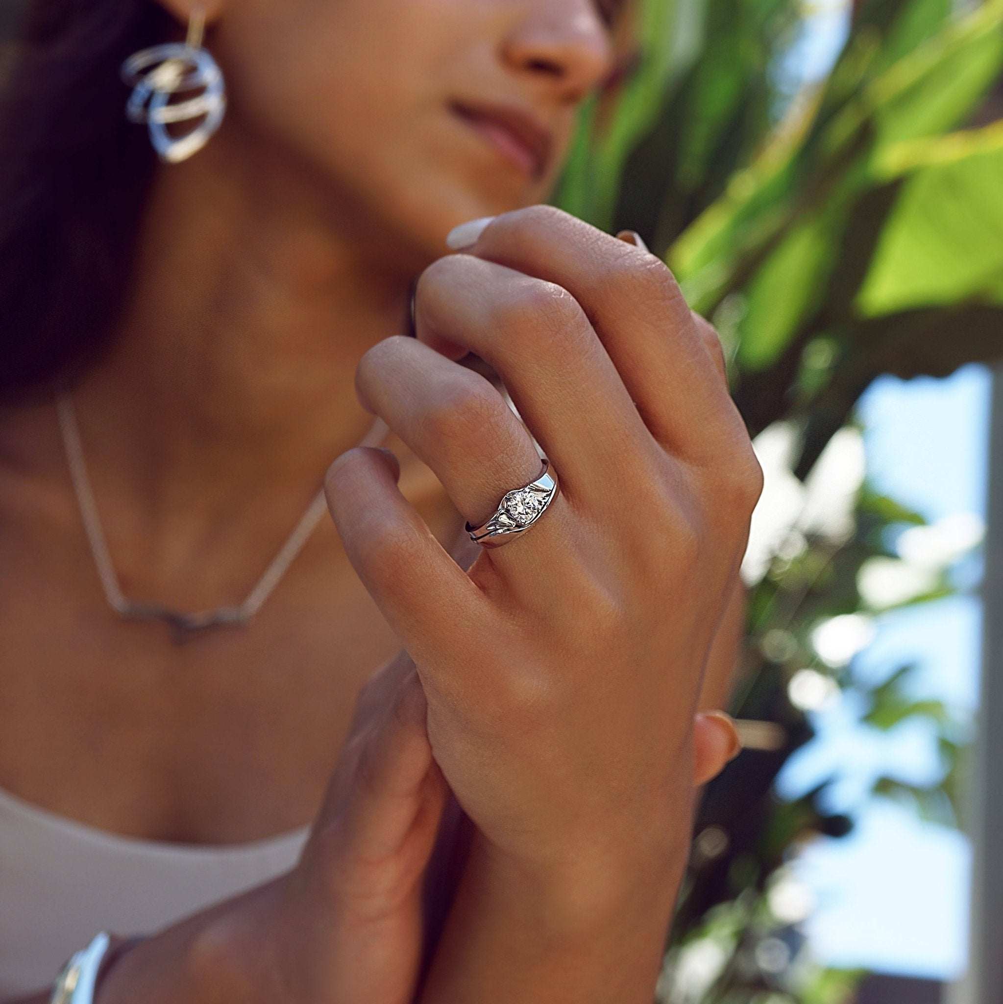 Close-up of a woman wearing the Iris Diamond Ring featuring a 0.5 carat round diamond with an intricate drapery-inspired design.