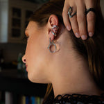 Silver Cascade Ear Cuff with undulating curves worn on ear with complementary rings on hand