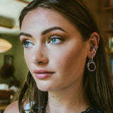 Woman wearing silver Cascade Ear Cuff with flowing sculptural design on lower ear beside lobe