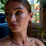 Woman wearing a sculptural Cascade Ear Cuff with flowing undulating curves in sterling silver, styled for elegant layered look