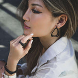 Woman wearing lightweight Aura Carbon black 3D printed carbon fiber earrings with misaligned loop design