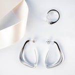 Silver Amare Aura Set featuring twisted ring and misaligned loop earrings with jewelry cleaning foam gift
