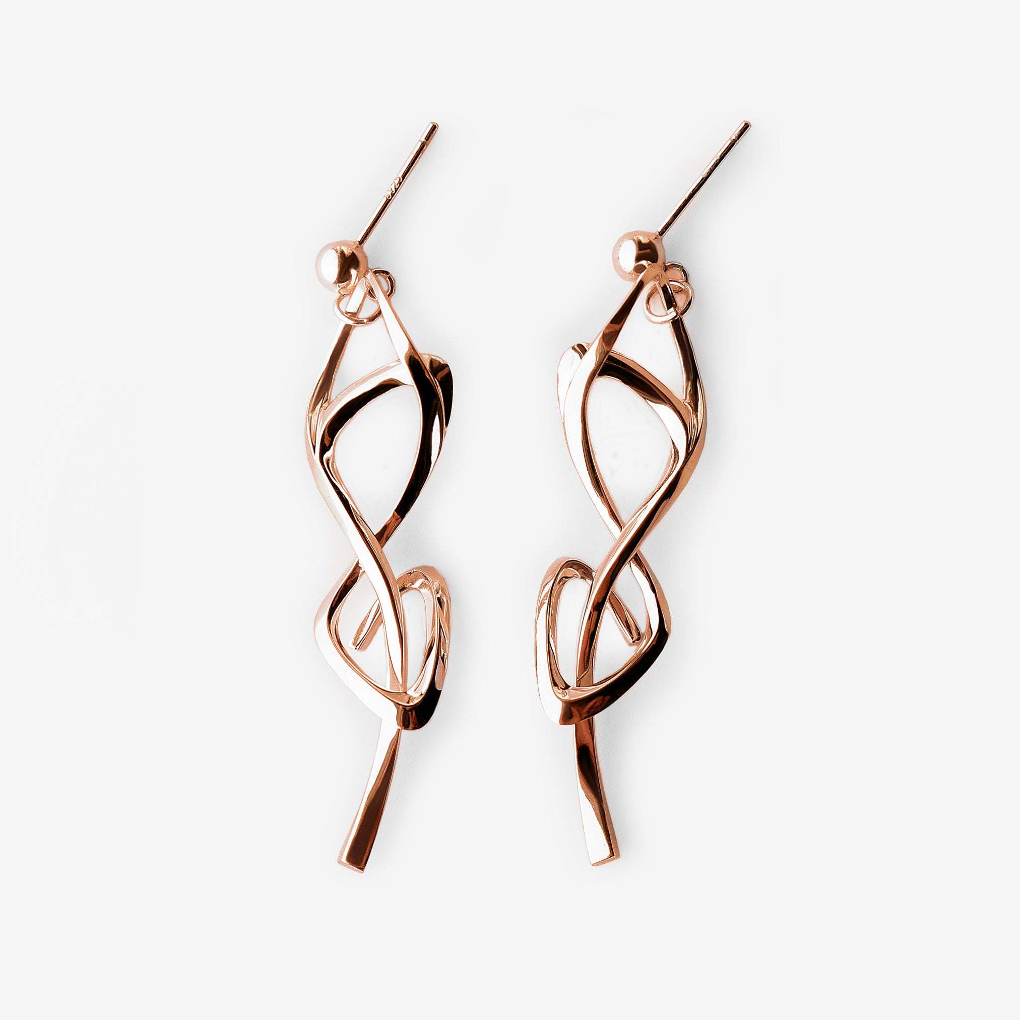 Rose gold Nova earrings with elegant undulating knot design and high-precision edges.