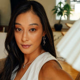 Close-up of a woman wearing sterling silver Nova earrings with an elegant loose knot design and high-precision edges in a modern indoor setting