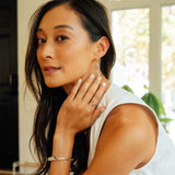 Woman wearing adjustable Hydra Duo ring with double-looped curves in sterling silver