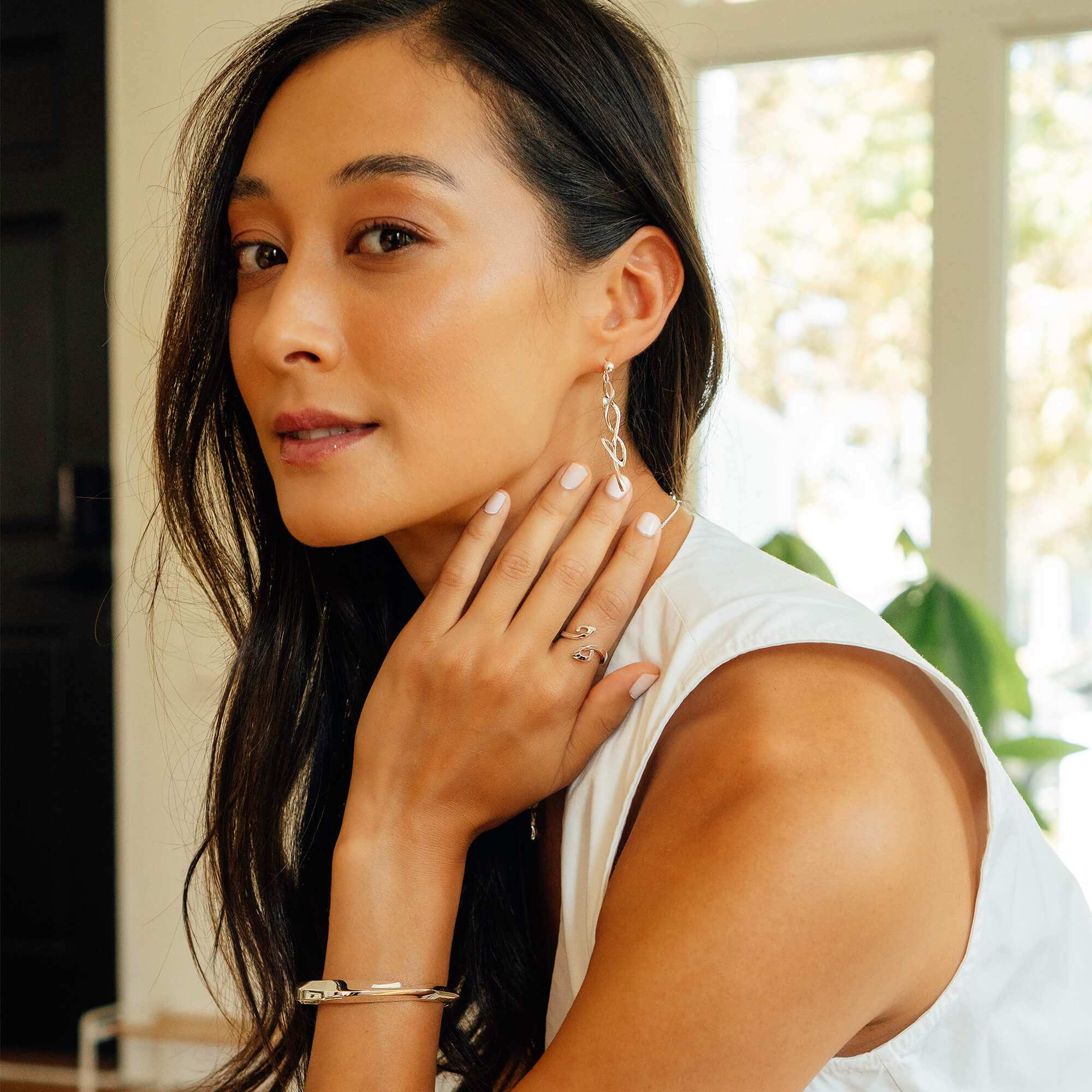 Woman wearing adjustable Hydra Duo ring with double-looped curves in sterling silver