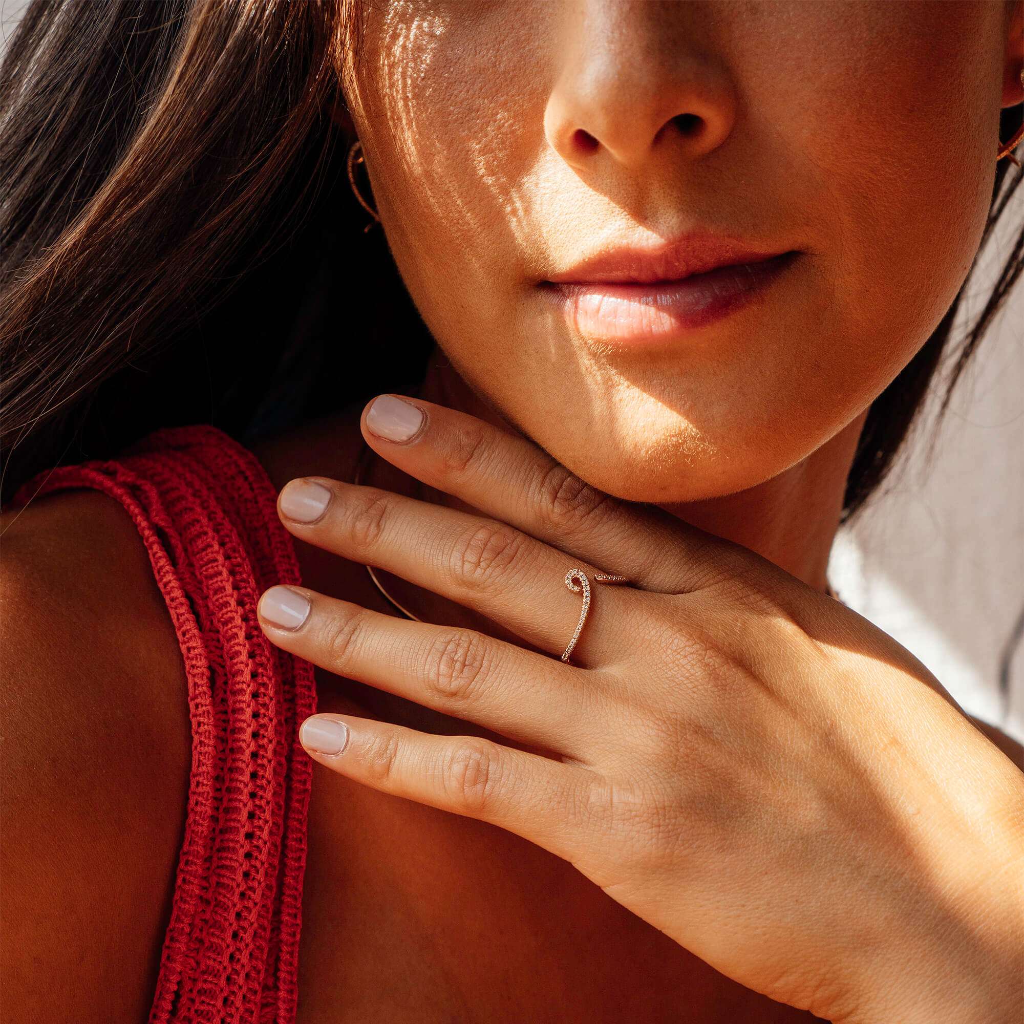 Close-up of woman wearing Hydra Diamond Ring in 14K gold with a delicate curved design and small round diamonds on finger