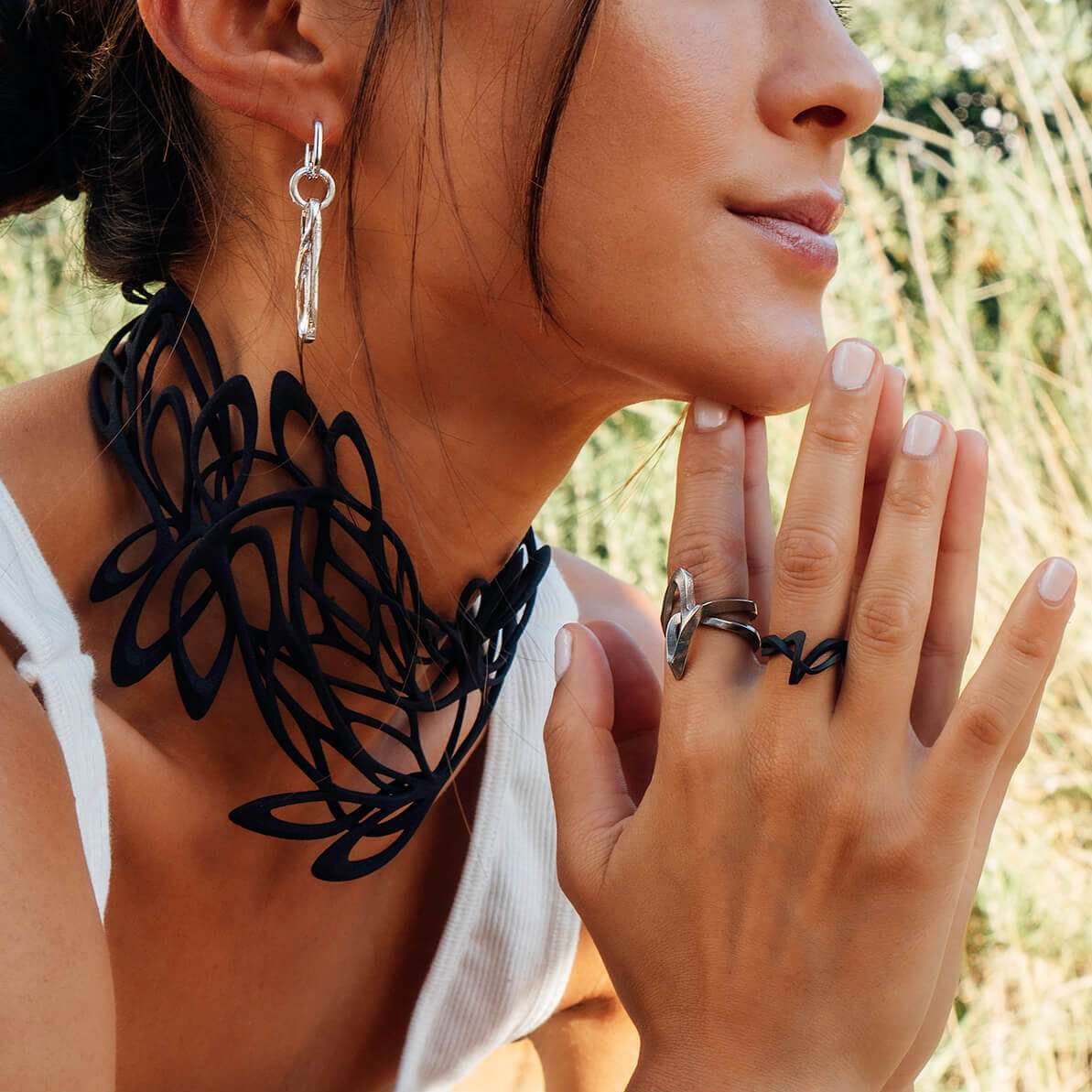 Close-up of a woman wearing the Amare Stainless Steel Ring with a unique loose knot design on her finger.