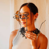 Woman holding LACE's exquisite 3D-printed nylon masquerade mask with intricate linework and precision edge detailing