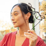 Woman holding LACE's exquisite 3D-printed nylon masquerade mask with intricate linework and precision edge detailing