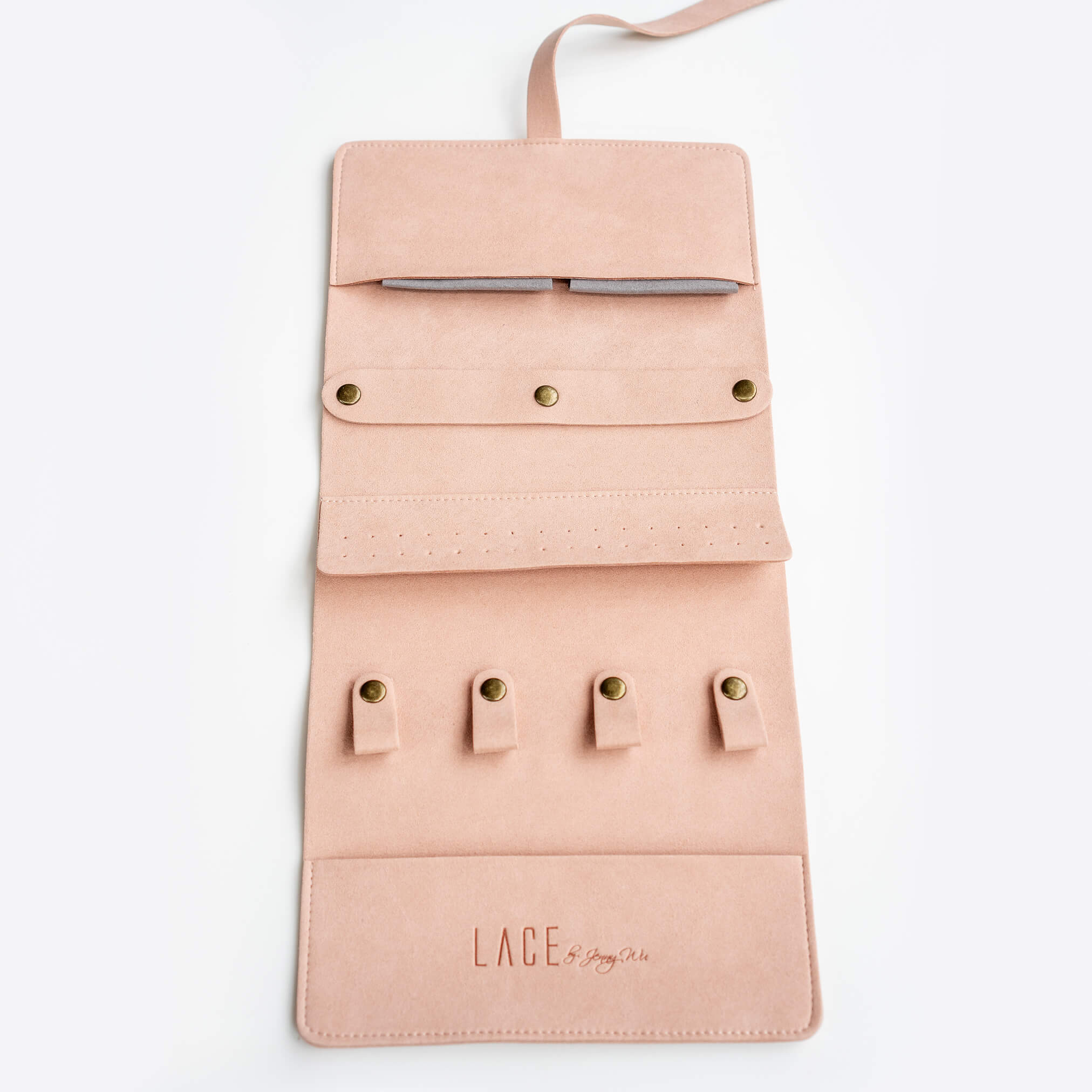 Pink travel jewelry roll organizer with multiple compartments for rings, earrings, necklaces, and bracelets by LACE