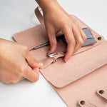 Soft pink travel jewelry roll organizer with compartments and gray pouch