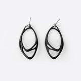 Eclipse Carbon Earrings made of 3D printed carbon fiber with two interlocking oval rings and precision edge detailing.
