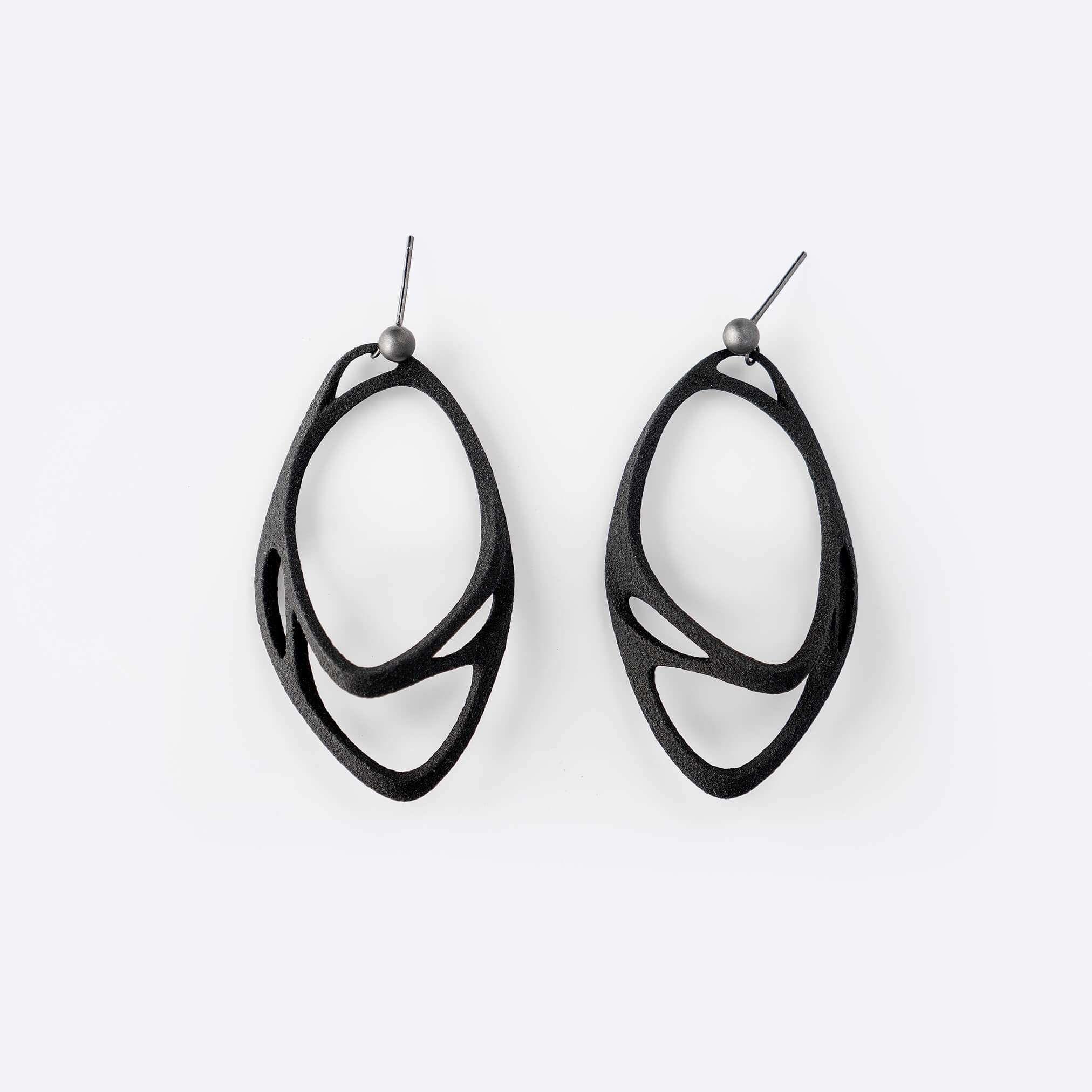Eclipse Carbon Earrings made of 3D printed carbon fiber with two interlocking oval rings and precision edge detailing.