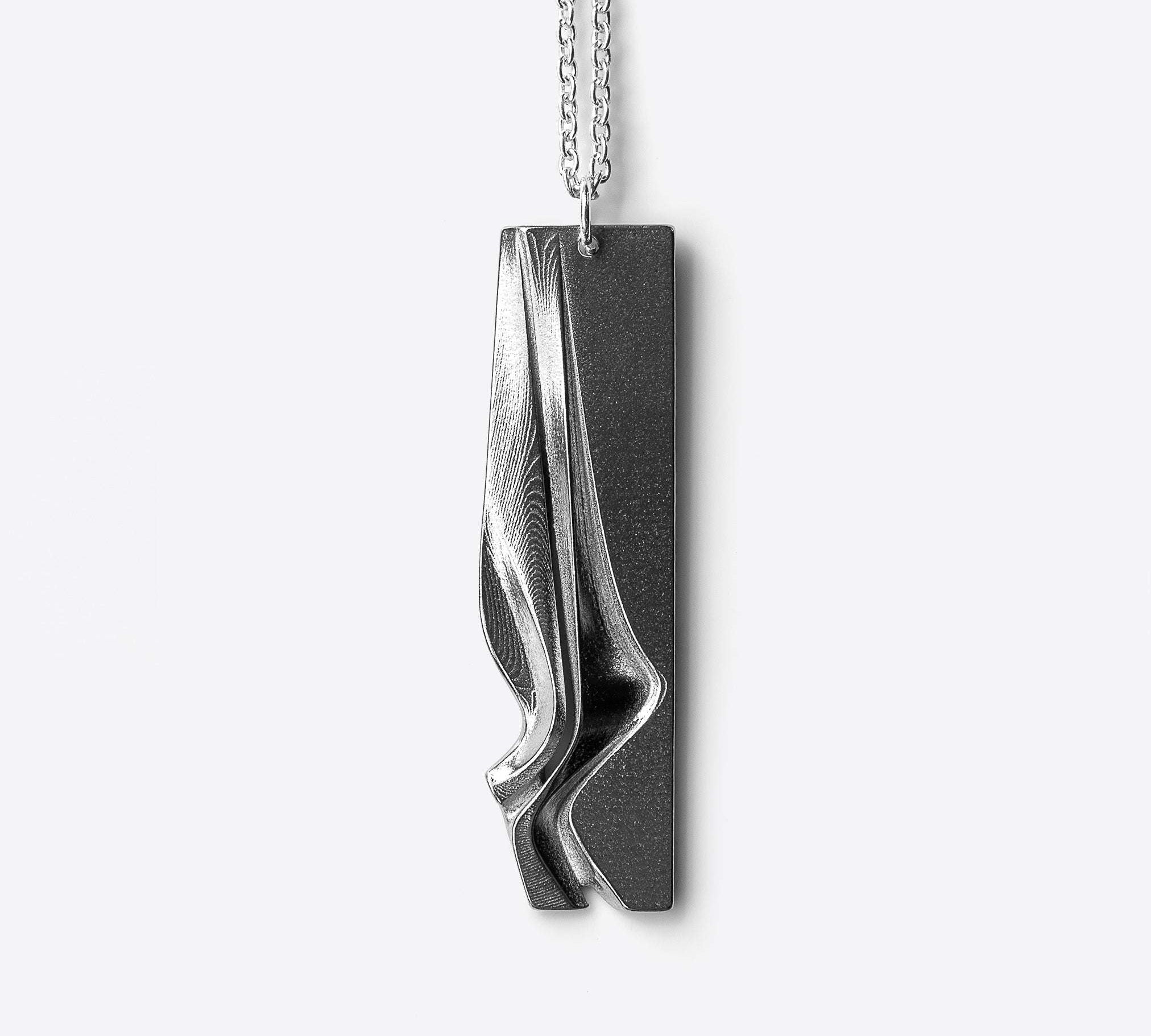 Nocturne Stainless Steel Pendant with twisting curves and precision edge detailing on a 22-inch chain
