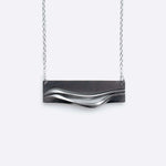 Adagio Stainless Steel Pendant with twisting stacking curves and precision edge detailing on a chain necklace