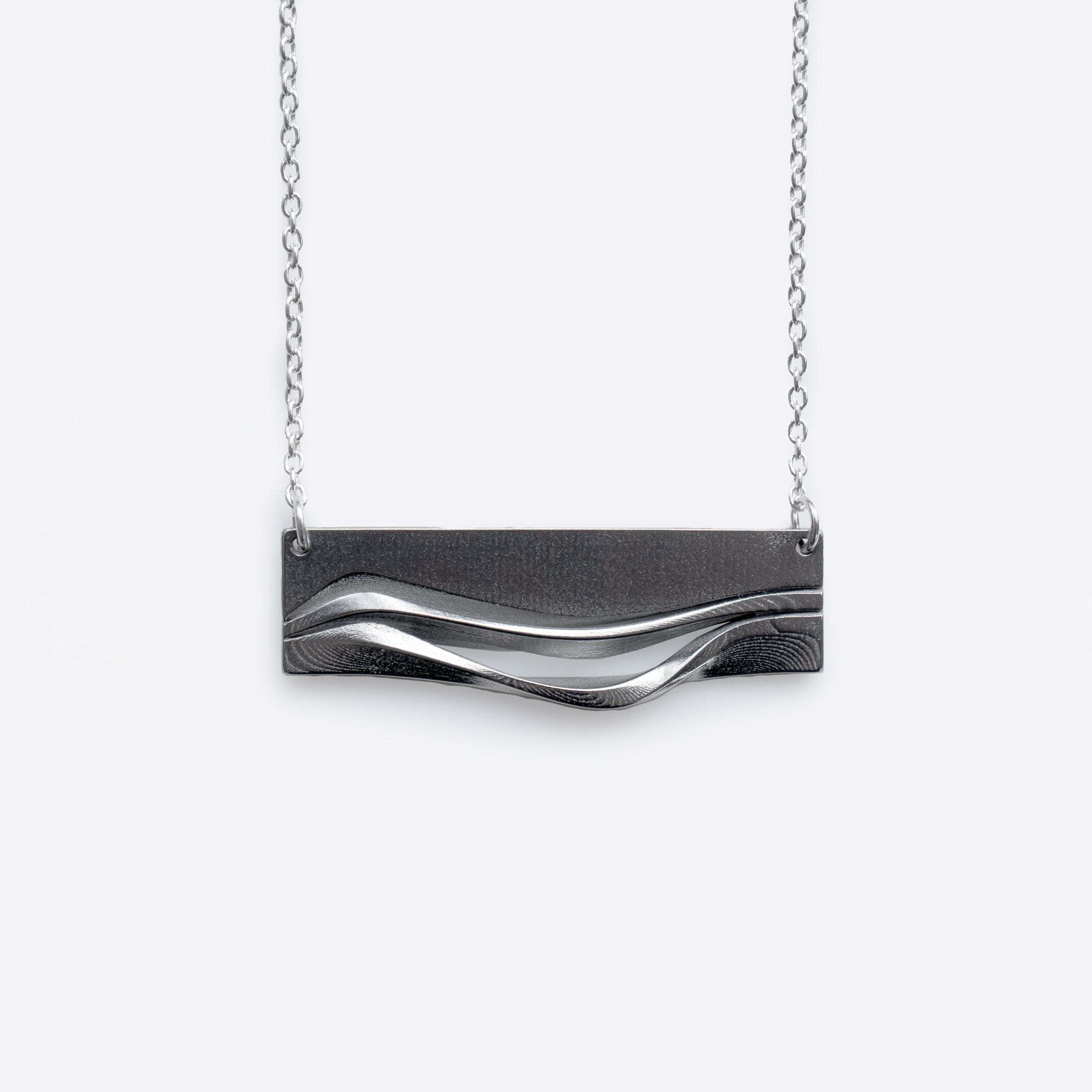 Adagio Stainless Steel Pendant with twisting stacking curves and precision edge detailing on a chain necklace