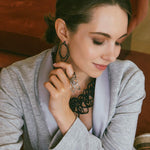 Woman wearing Eclipse Carbon Earrings with layered oval rings in carbon fiber and 3D printed design