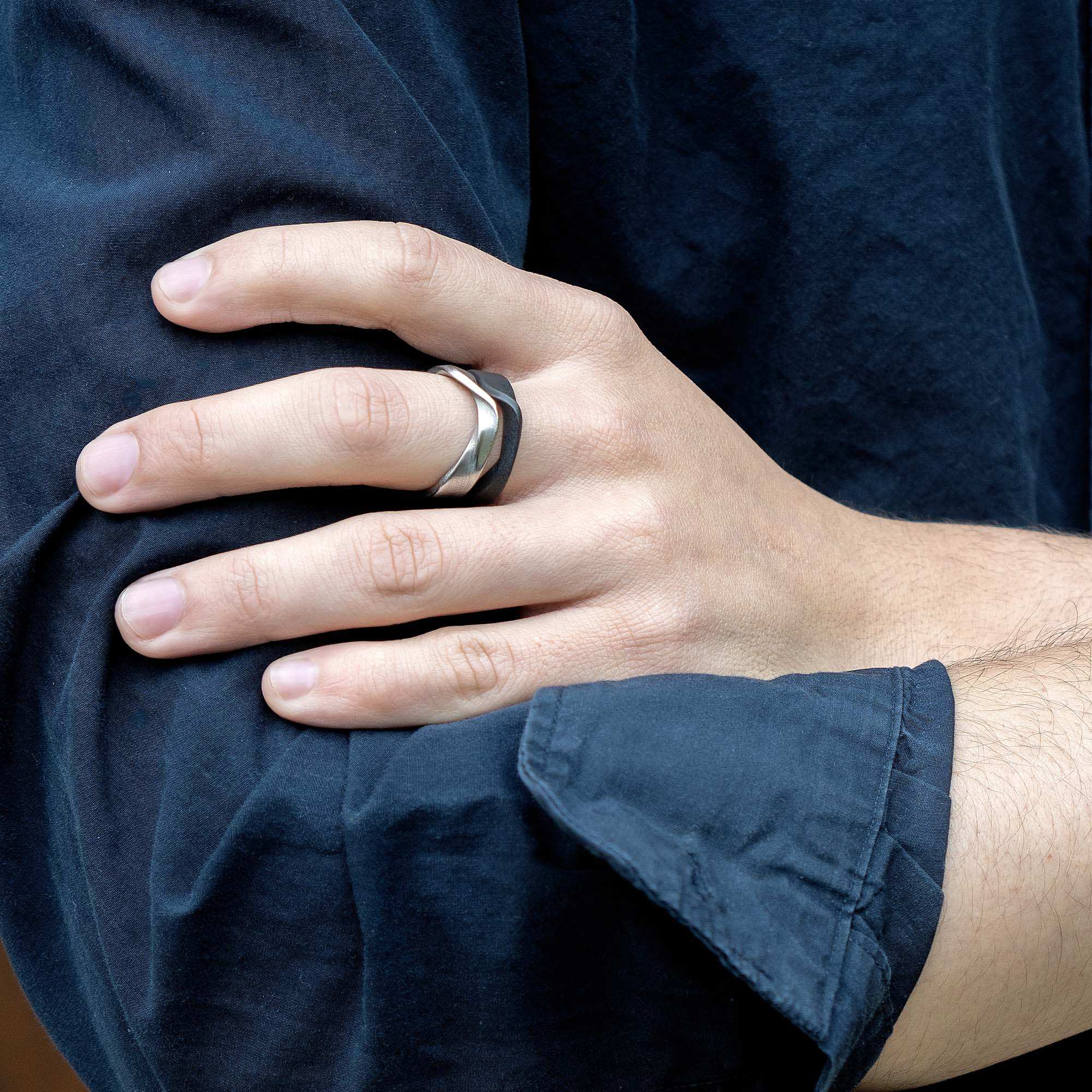 Amor Stainless Steel Ring bold twisted band on finger with dark shirt background