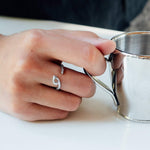 Hydra Stainless Steel Ring on finger holding silver cup with an open curved oval loop design