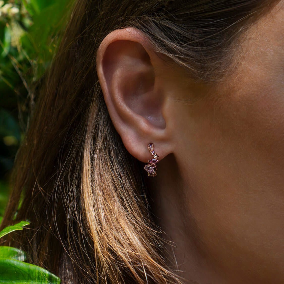 Close-up of ear wearing Leda Earrings with lilac and pink gemstones in 18K rose gold vermeil hoop design