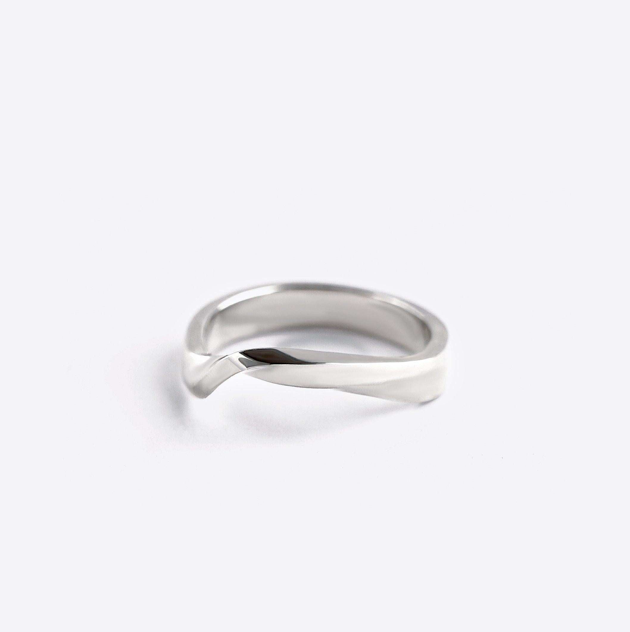 Sterling silver Amor Amos Light Set twisting band ring with precision edge detailing on white background