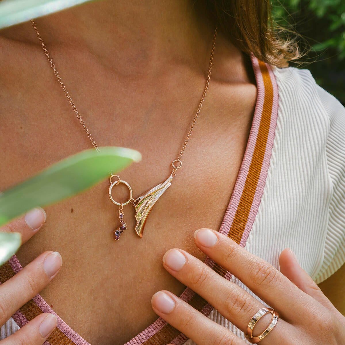 Close-up of Leda gemstone necklace in 18K rose gold vermeil with amethyst and pink stones worn on model's neck