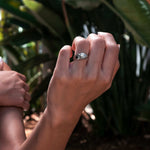 Close-up of hand wearing Iris Diamond Ring with 0.5 carat round diamond and intricate drapery design outdoors