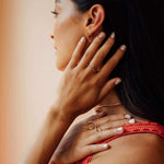 Close-up of a woman wearing a 14K gold Hydra Diamond Ring with a sculpted oval loop, showcasing delicate diamond accents and minimalist design.