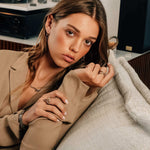 Woman wearing X Steel Ring with crossed tapering lines and precision edge detailing on her finger