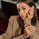Woman wearing L Steel Ring with twisting lines and precision edge detailing on finger