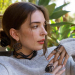 Woman wearing Legato black 3D printed TPU choker necklace and matching earrings with gray sweater outdoors