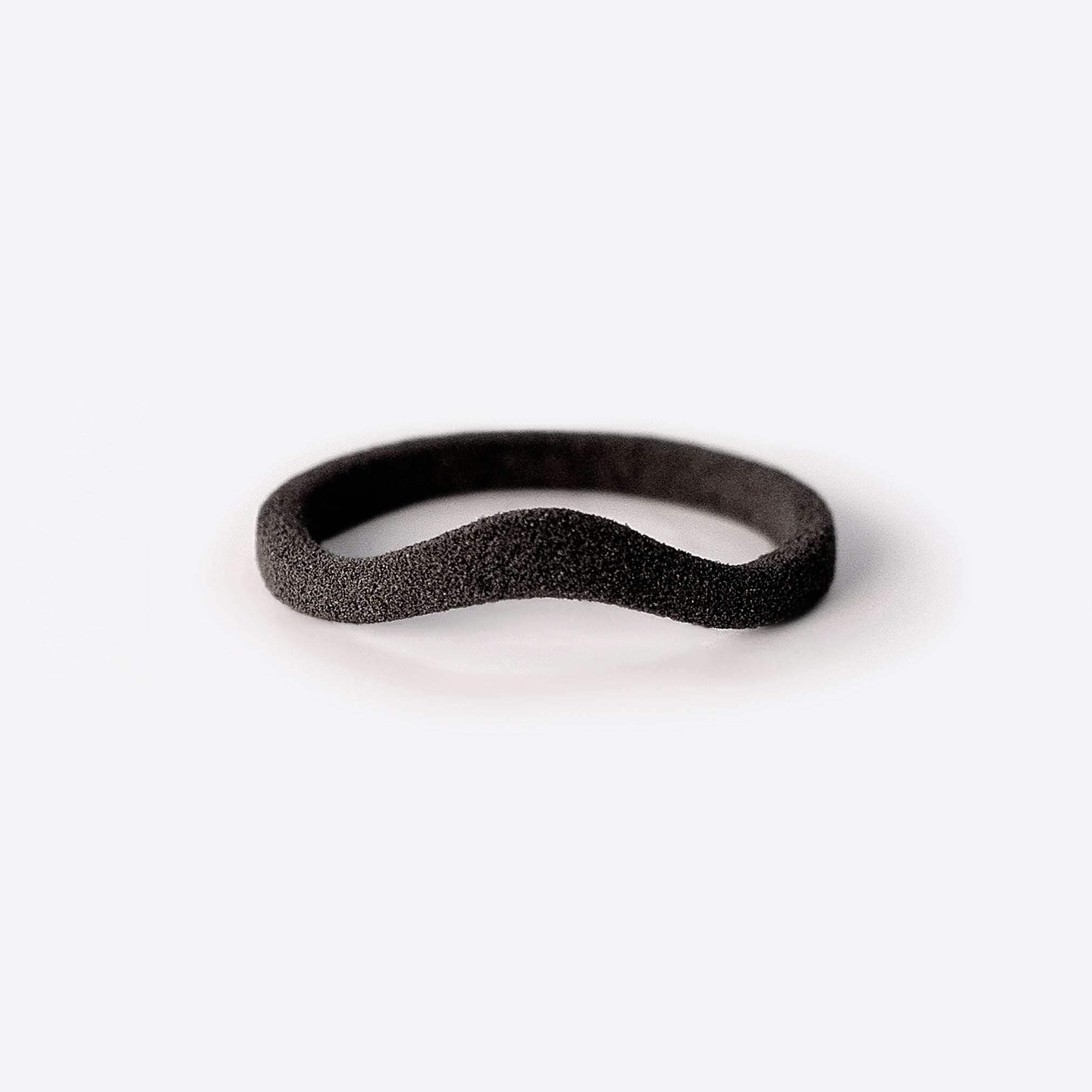 Gray nylon Lyra sample ring with a curving band design on white background