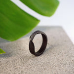 Amor Bold Steel Ring in gray steel with twisted band and precision edge details on stone surface