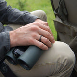 Close-up of hand wearing gray steel Amor Bold Steel Ring holding binoculars outdoors