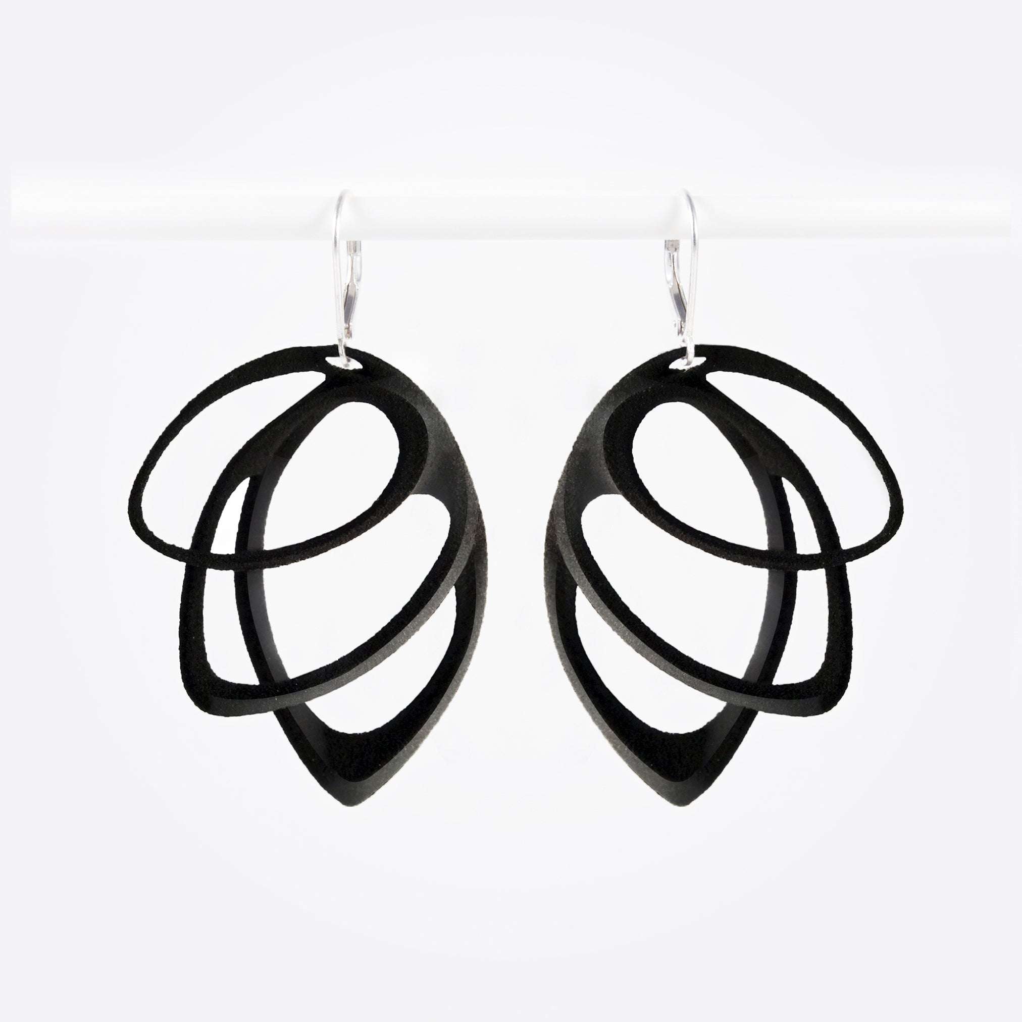 Black polished Orbis Nylon Earrings with three elliptical open loops in descending sizes, hanging on silver hooks