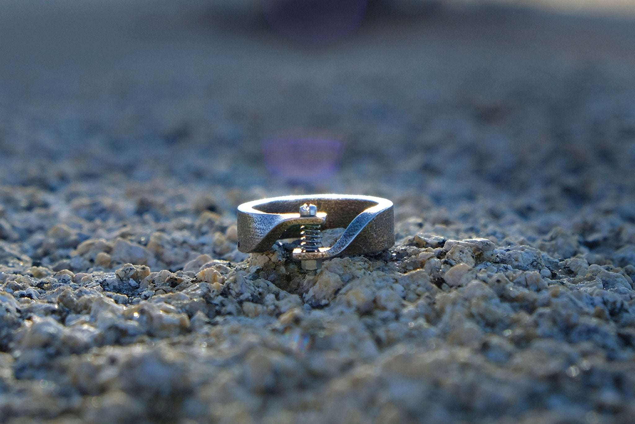 Mechanical industrial style men's ring with screw and bolt detail on rough stone surface Father's Day Gift Guide
