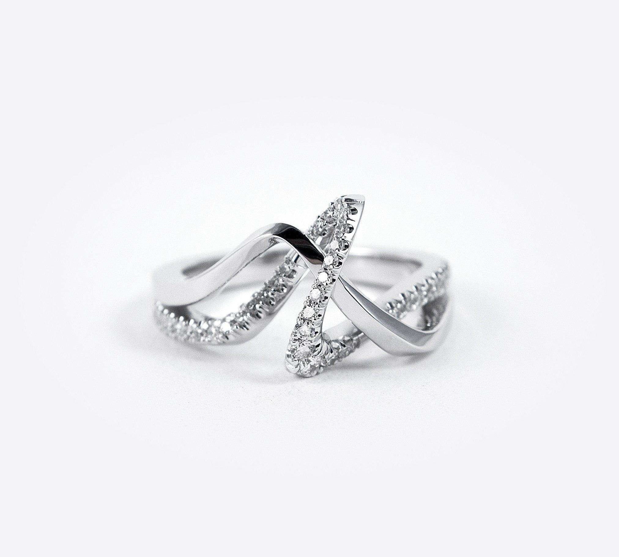Amare Diamond Ring featuring a unique loose knot design with intertwined diamond-pave and polished metal lines