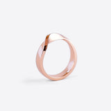 18K rose gold Amor Amos Light Set stackable twisting band ring on white background