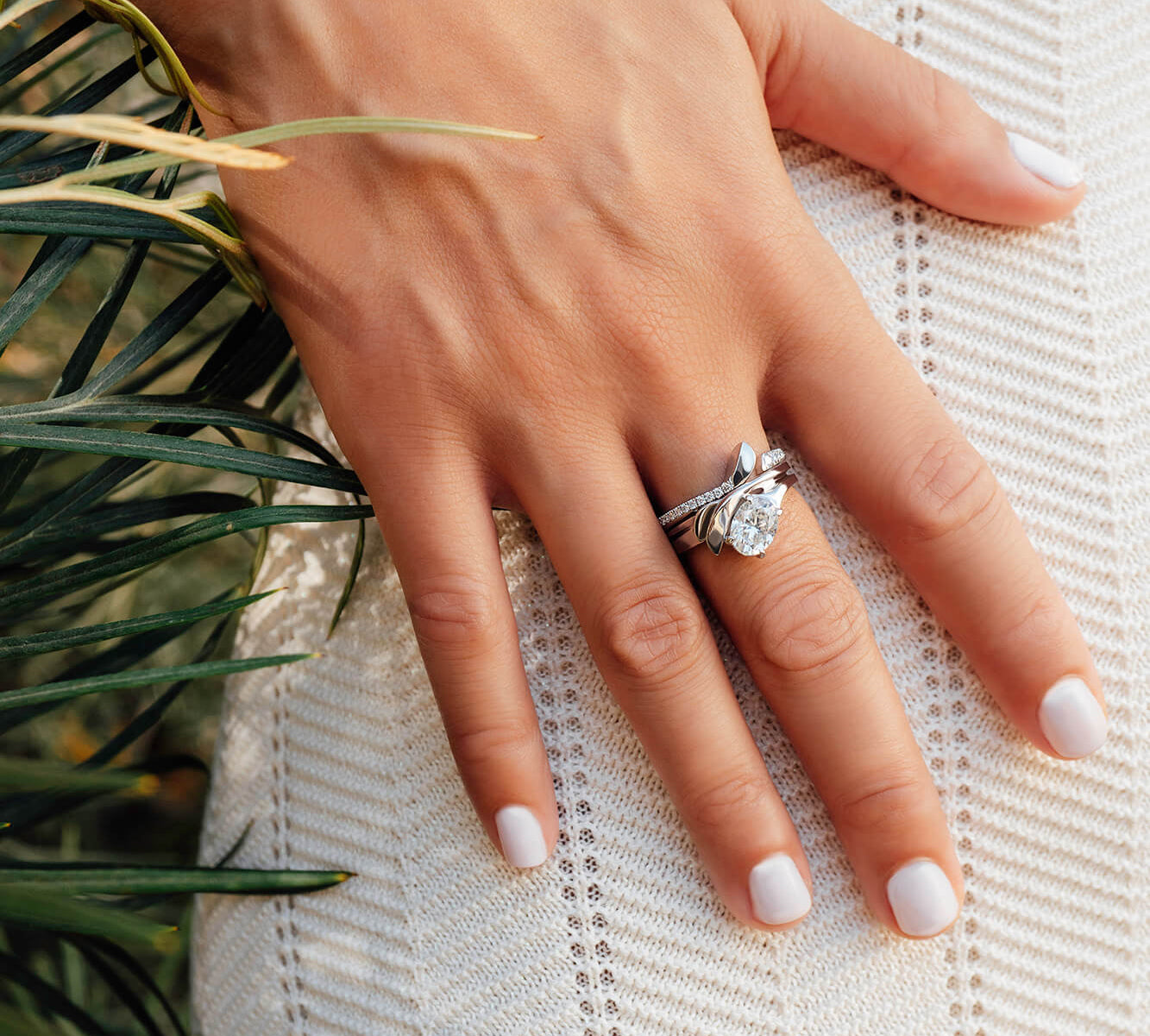 Hand wearing engagement ring from the Engagement Ring Samples Set on white lace fabric background