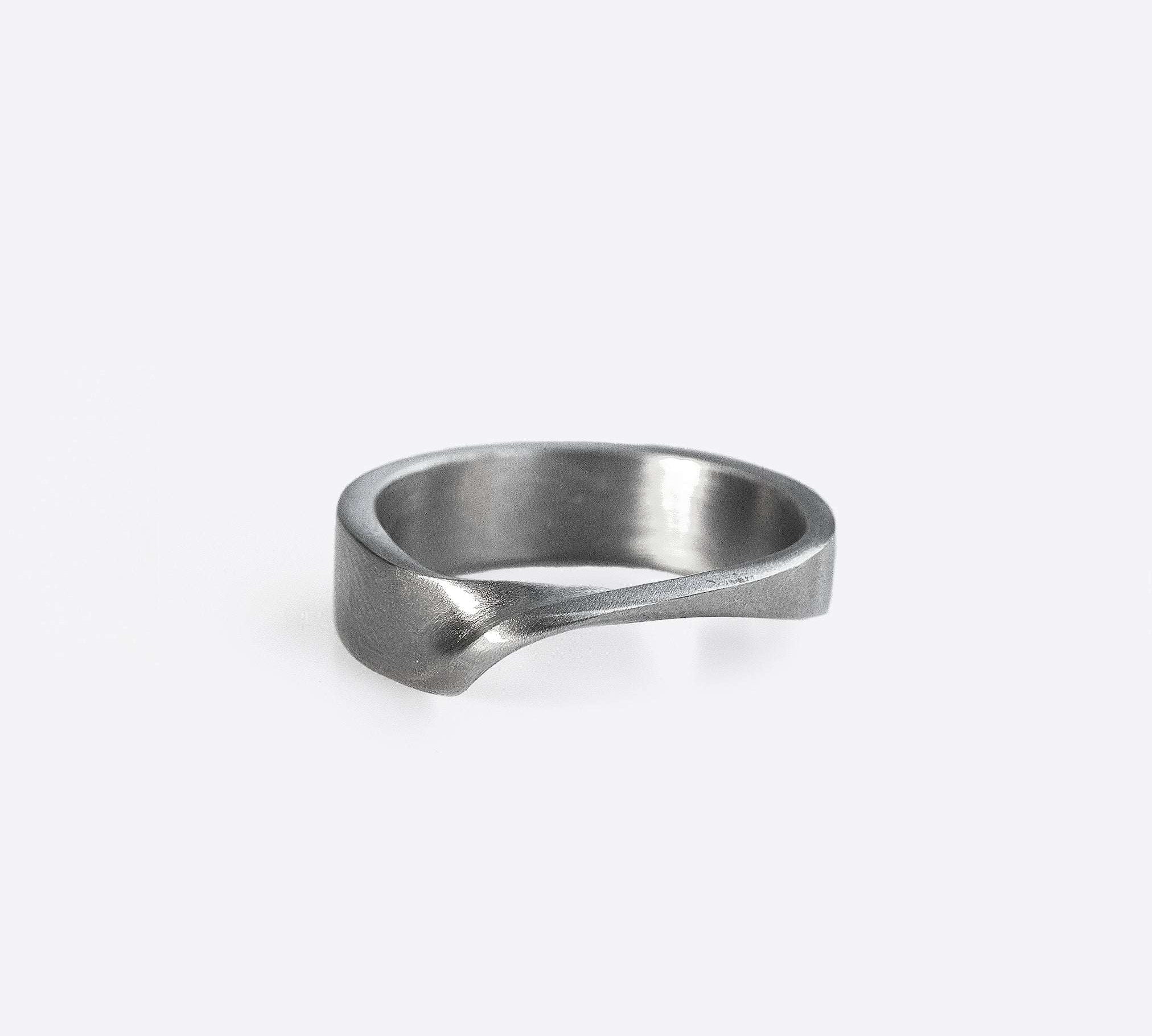 Amor stainless steel ring with clean line design and twisting band detail on white background
