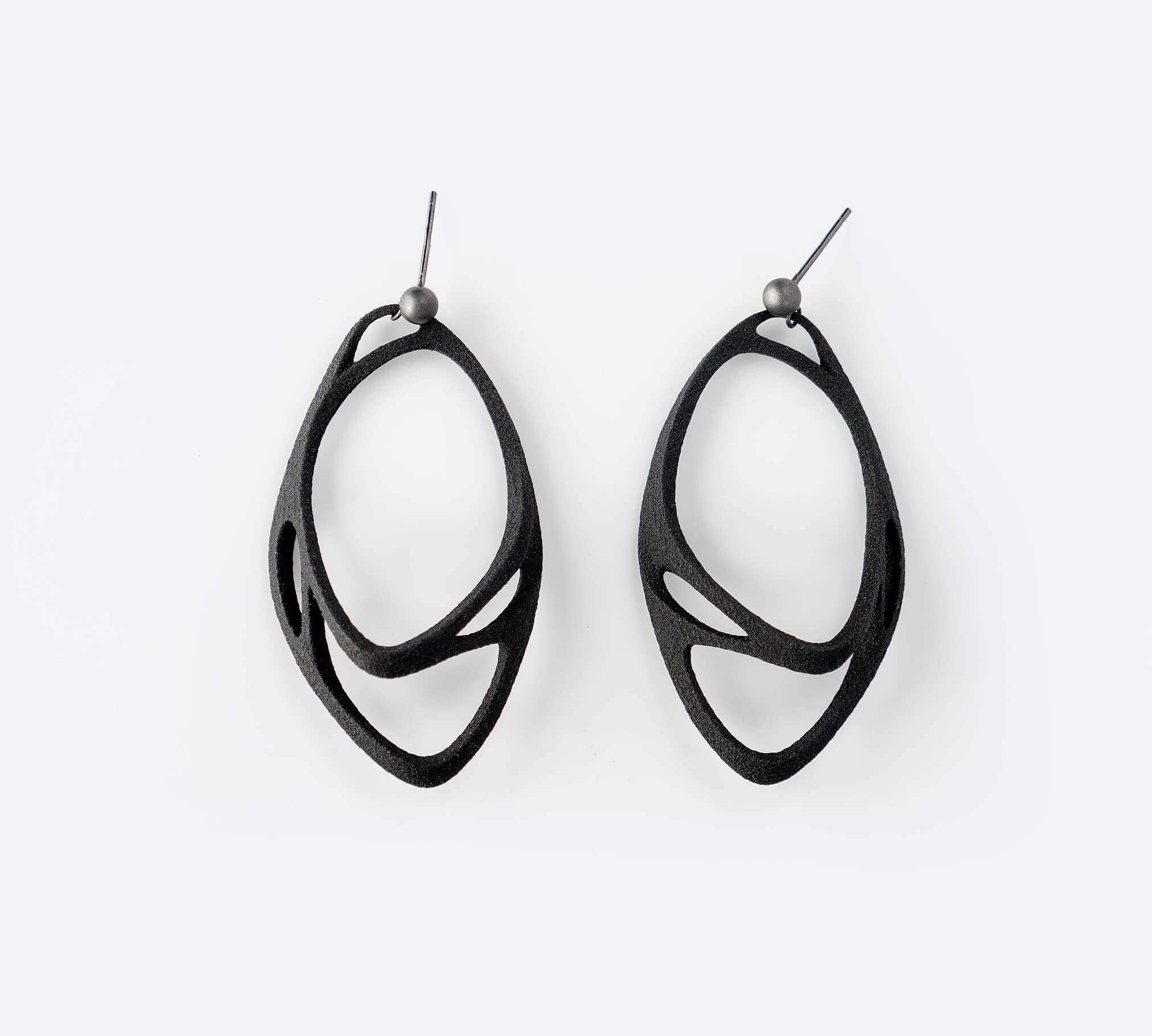 Eclipse Carbon Earrings made of 3D printed carbon fiber with two interlocking oval rings and precision edge detailing.