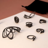 Set of black nylon ring samples from LACE collection displayed with a black velvet pouch on a beige surface